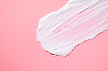 Cosmetics texture. Smear of white face or body cream, lotion, mousse, soap, shower gel on pink...