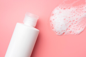 Cosmetic template mockup. White plastic bottles with air foam on pink background. Face wash, mousse, soap, shampoo, shower gel. Beauty, spa, skin care, cosmetic product top view flat lay