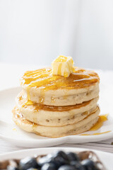Pancake with butter and honey maple syrup set on white cafe table. - 578353196