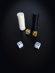 Gambling chips and dice. Dice and chips on a black background.