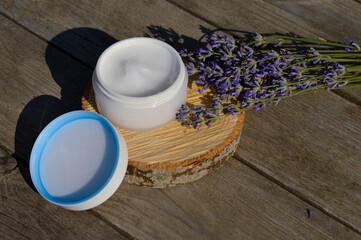 organic lavender flowers, moisturizer cream on wooden background. The concept of beauty and wellness. Skincare and body