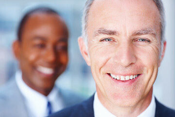 Senior executive with partner in distance. Closeup of friendly Business man with man in background.