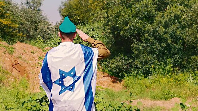 Israeli Army Soldier salutes with a large Flag of Israel on his back. Video themes: Army, IDF - Tzahal  or Israel Defense Forces, Independence Day Israel, Soldiers, Patriotism