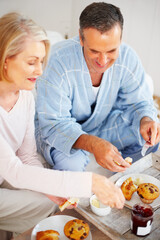Obraz na płótnie Canvas Smiling mature couple together having breakfast. Portrait of a smiling mature couple together having breakfast.