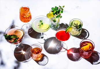 Most popular cocktails set: aperol spritz, negroni, mojito, gin tonic and cosmopolitan, daiquiri, margarita and old fashioned on white background, top view. Hard light © 5ph