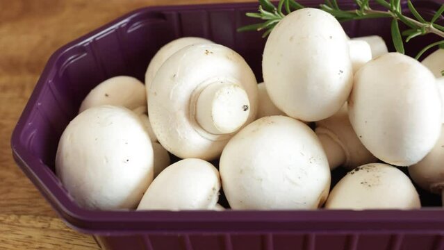 barquette de champignons de paris frais, en gros plan, sur une table