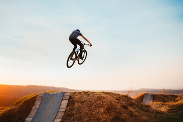 Fototapeta na wymiar Young man on a mountain bike performing a dirt jump