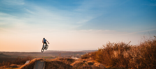 Fototapeta Young man on a mountain bike performing a dirt jump obraz