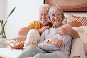 Love lives forever! Senior couple portrait at home. Handsome old man and attractive old woman are...