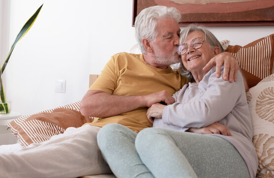 Love lives forever! Senior couple at home. Handsome old man and attractive old woman are enjoying spending time together while lying in bed. - Powered by Adobe