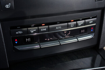 Modern car climate control panel for driver and passenger with shallow depth of field. Zone climate control. Car interior detail.