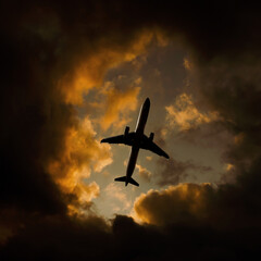 Airplane flies through orange dramatic clouds