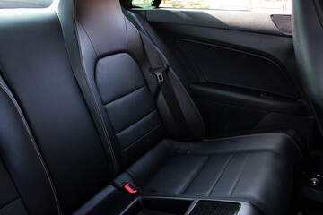 Comfortable black leather car soft clean rear seat. Black Leather interior design, car passenger clean, angle view side. Back passenger seats in modern comfortable car.