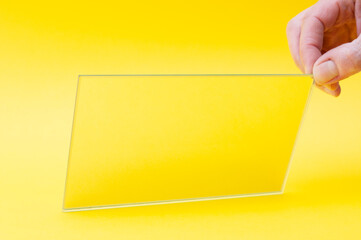 Rectangular mirror in hand on a yellow background
