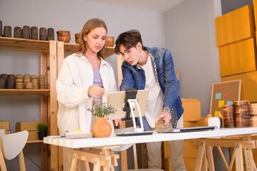 A young couple entrepreneur checking and packaging craft products selling to customers in them shop