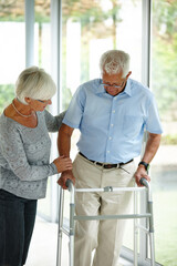 Motivation is all it takes...a senior woman helping her husband to walk with his walker.