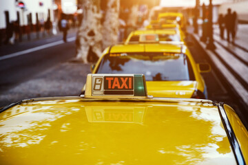 Close-up of a taxi sign on a classic yellow car.