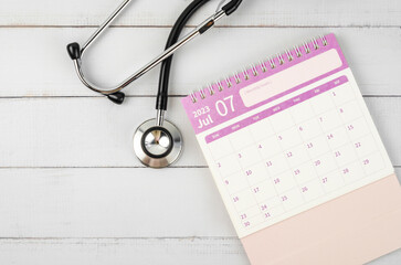 The June 2023 desk calendar and stethoscope medical on wooden background, schedule to check up healthy concepts.