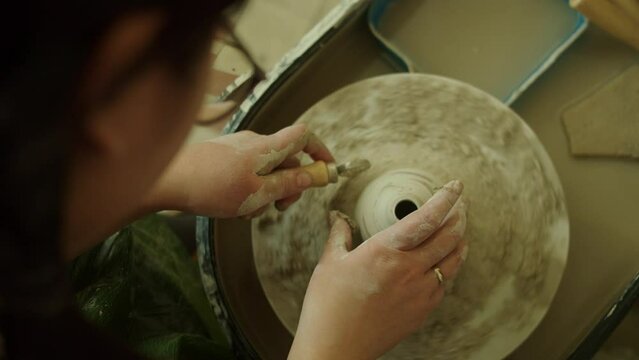Girl works in her atmospheric craft workshop pottery studio