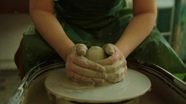 Girl works in her atmospheric craft workshop pottery studio
