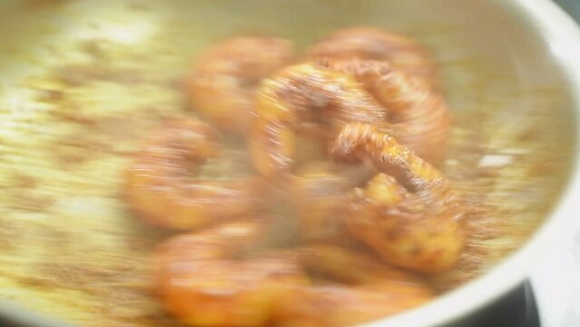 Cooking and stirring shrimps in the frying pan.
