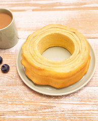 Baumkuchen, sakotis ,sekacz on wooden rustic table with cup of coffee, blueberries, traditional spit cake of lithuanian, polish, german, belarusian cuisine made of butter,eggs,flour,sugar. Vertical