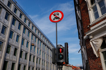 Selective focus view at red traffic light and No entry for car and motorcycle sign against blue sky...
