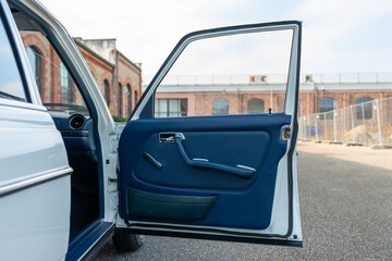 Open car front door with a brick building in the background