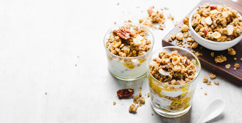 Granola and Yogurt Parfaits, Healthy Breakfast or Snack, Muesli with Nut Mix and Honey on Bright Concrete Background