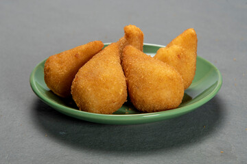 traditional fried coxinha in plate on slate background, popular brazilian snack