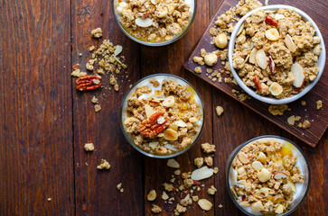 Granola and Yogurt Parfaits, Healthy Breakfast or Snack, Muesli with Nut Mix and Honey on Wooden Background