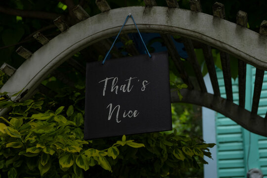 Sign that's nice hanging at a garden arch at a residential house.