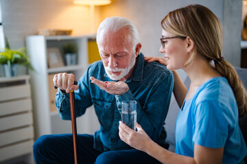 Fototapeta premium Female GP doctor giving pills to older male patient at appointment. Practitioner prescribing medicine to senior 80s man, drugs for mental health, geriatric disease prevention, dementia treatment