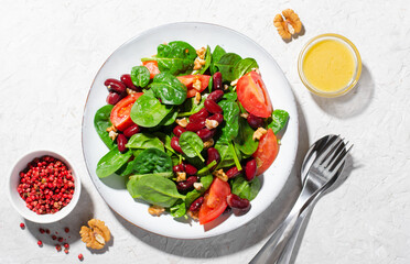 Red Bean Salad On Bright Background, Fresh Salad with Spinach, Cherry Tomatoes, Walnuts, Beans and Mustard Dressing