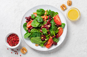 Red Bean Salad On Bright Background, Fresh Salad with Spinach, Cherry Tomatoes, Walnuts, Beans and Mustard Dressing