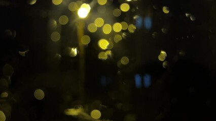 bokeh effect of street lights and drops in rainy night