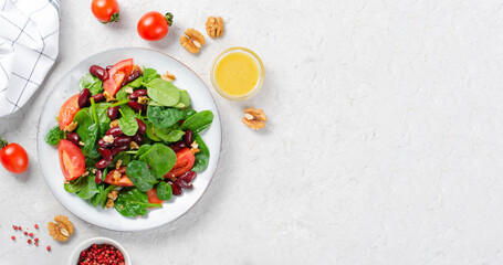 Red Bean Salad On Bright Background, Fresh Salad with Spinach, Cherry Tomatoes, Walnuts, Beans and Mustard Dressing