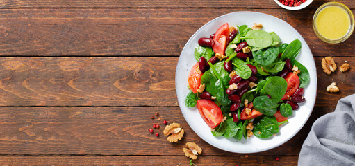 Red Bean Salad On Wooden Background, Fresh Salad with Spinach, Cherry Tomatoes, Walnuts, Beans and Mustard Dressing