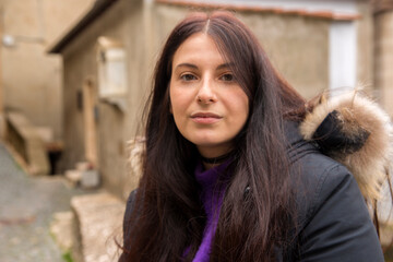 Beautiful sad girl in an Italian village. Young caucasian woman on the street in winter.