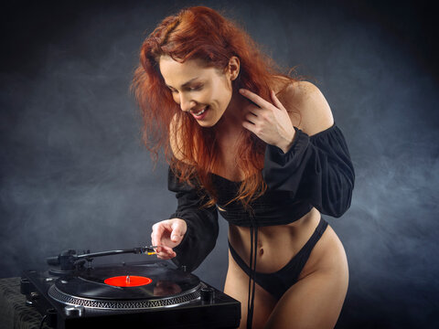 Beautiful sexy woman listening to vinyl on her turntable