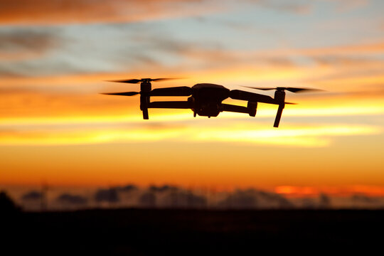 Flying drone in a sunset sky.