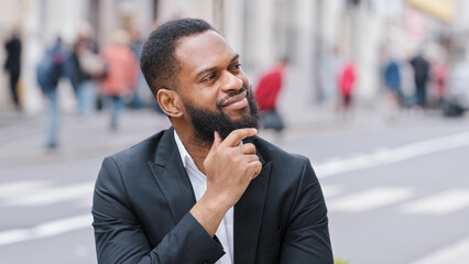 Close up portrait bearded ethnic man outdoors African American businessman looking away thinking about future think pensive thoughtful entrepreneur in city dreaming pondering idea searching solution - obrazy, fototapety, plakaty