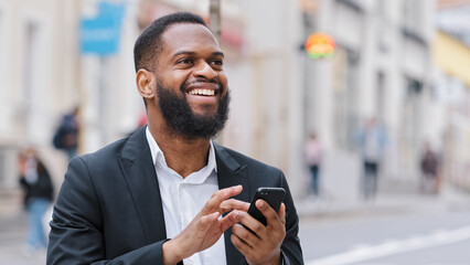 African American bearded man with smartphone navigation application looking for address using...