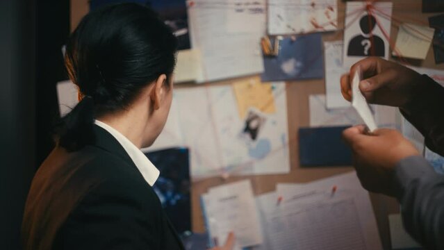 Female detective showing evidence bullet to ballistic expert crime investigation