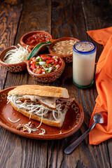 tradicional torta de carne de puerco, con agua fresca de horchata, torta ahogada tipica de guadalajara, jalisco, mejico