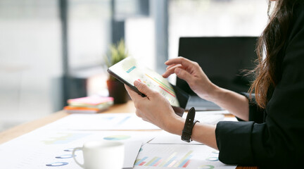 Businesswoman using digital tablet analyze about business growth to plan future new business at office.