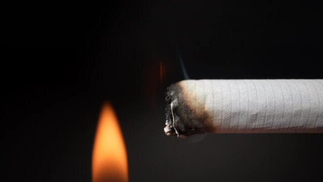 They set fire to a cigarette with a lighter. close-up