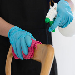 Close up employees' hands were wiping the chairs to clean after the customers finished their meal, Using cleaning solutions or using alcohol to kill germs in the restaurant.