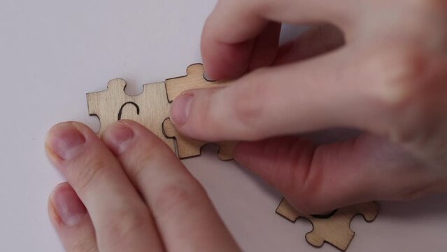 Woman assembling the word CHD from wooden puzzles on a white background. Health care concept for hospital, clinic and medical business. Abbreviation for coronary heart disease.