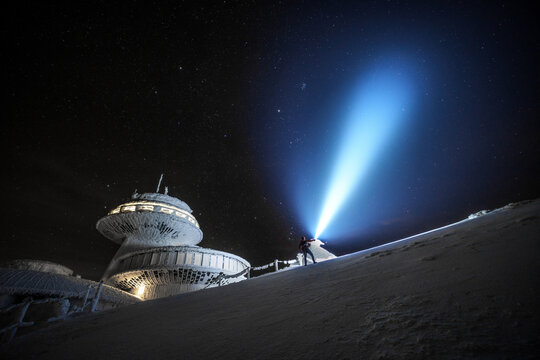Flashlight beam lighting to the sky in the mountains during the night